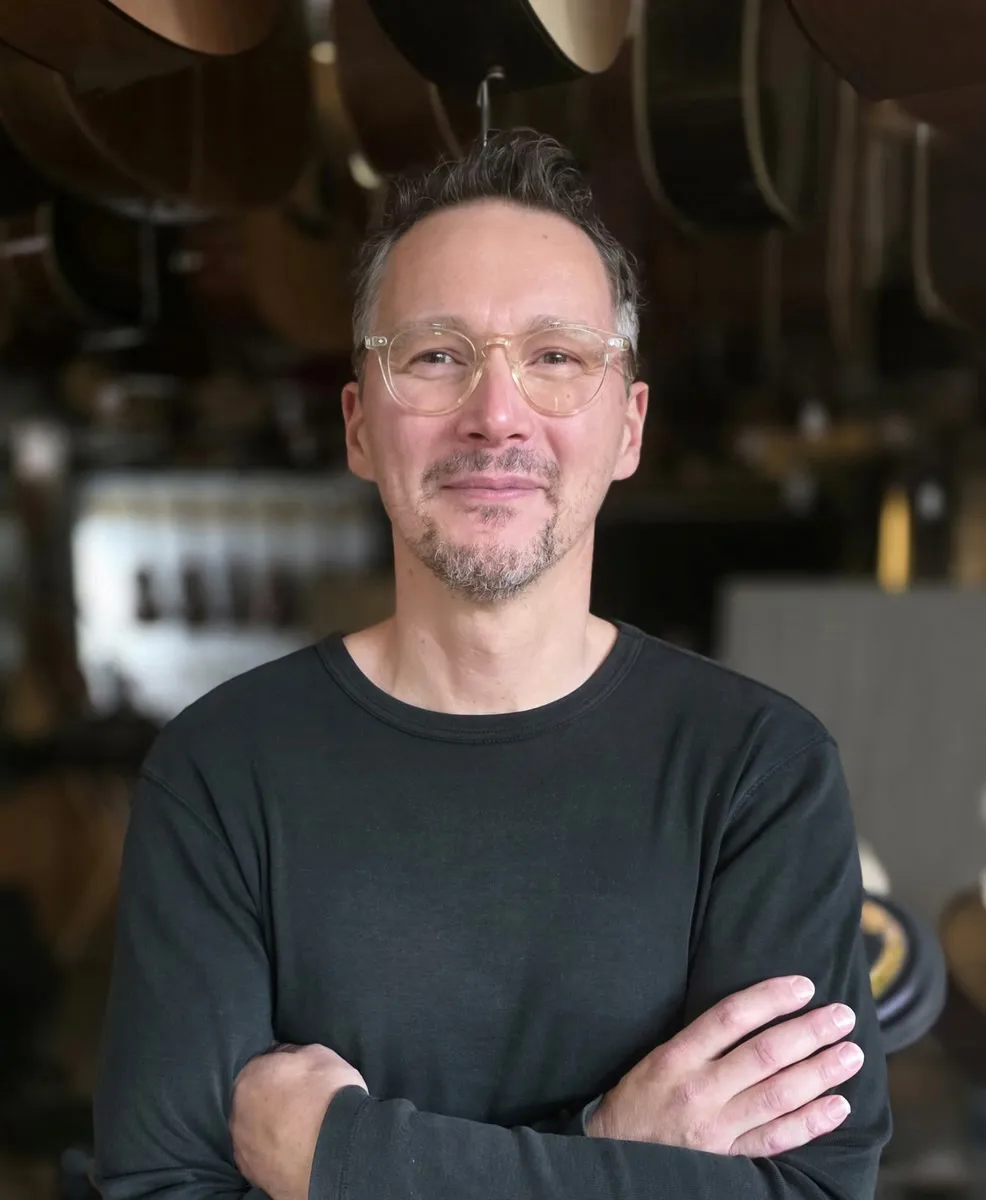 Thierry, conseiller chez Azzato, devant le mur d’instruments du magasin