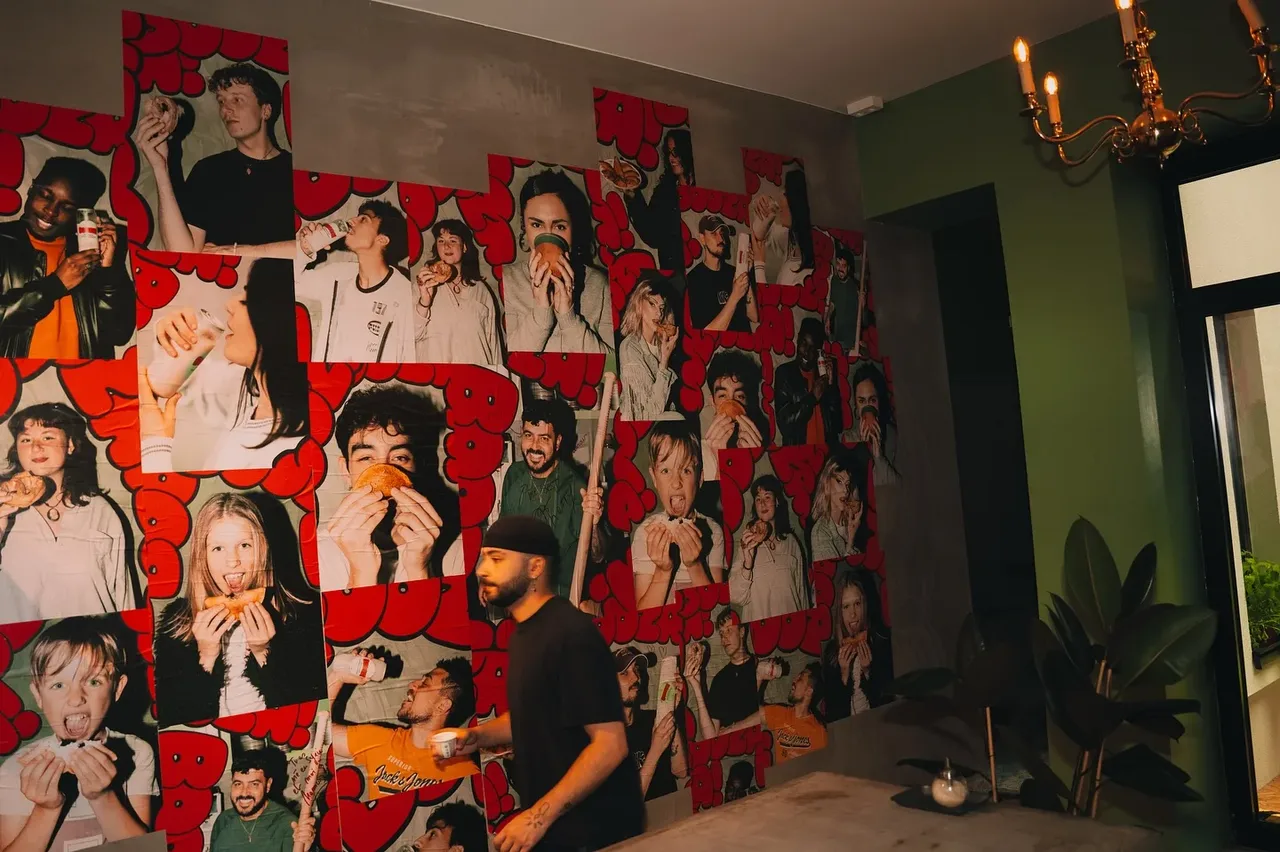Le mur d'affiches Booza! vu de côté, dans la salle aux murs verts