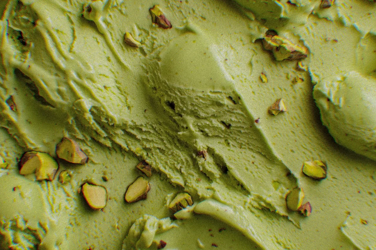 Gros plan d'une glace à la pistache striée, parsemée d'éclats de pistache, la booza qui a donné son nom au café