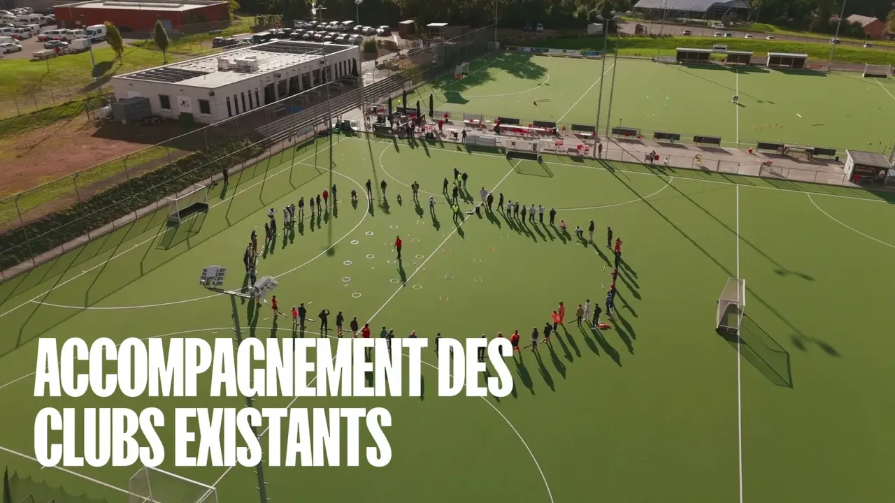 Vue drone d'un terrain de hockey, joueurs en cercle, titre « Accompagnement des clubs existants » en surimpression