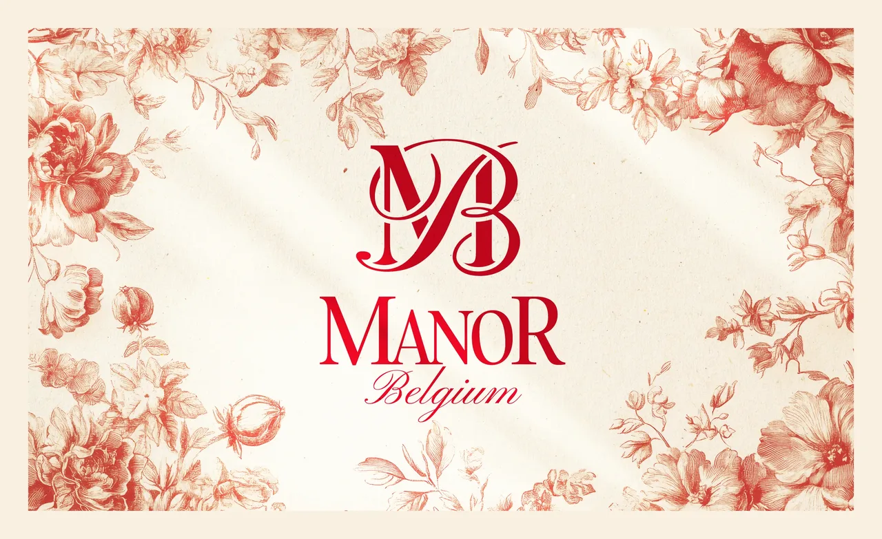 Monogramme MB et logotype Manor Belgium en rouge, encadrés d'un motif de fleurs gravées façon toile de Jouy