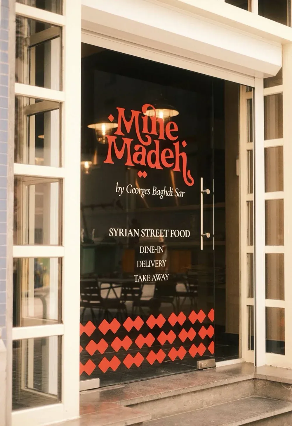 Porte vitrée de Mine Madeh : logo corail, « by Georges Baghdi Sar », « Syrian street food » et frise de losanges