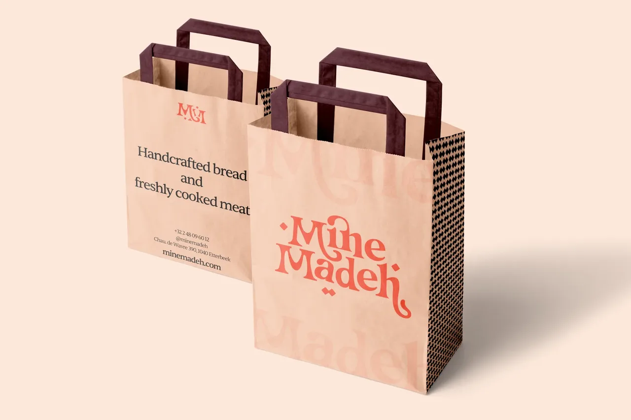 Sacs kraft Mine Madeh à anses bordeaux, logo corail et mention « Handcrafted bread and freshly cooked meals »