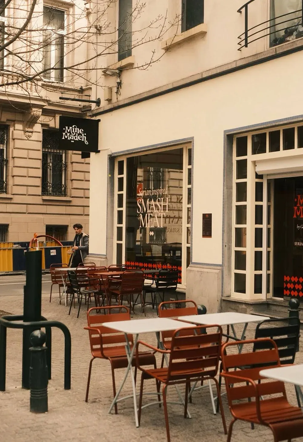 Terrasse du restaurant Mine Madeh à Bruxelles, vitrines habillées et enseigne drapeau sur la façade